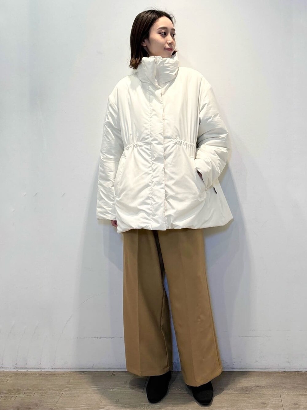 イエロー系のその他パンツ、グレー系のニット/セーター、ホワイト系のその他アウターを着用したレディースの冬コーディネートの4枚目の写真