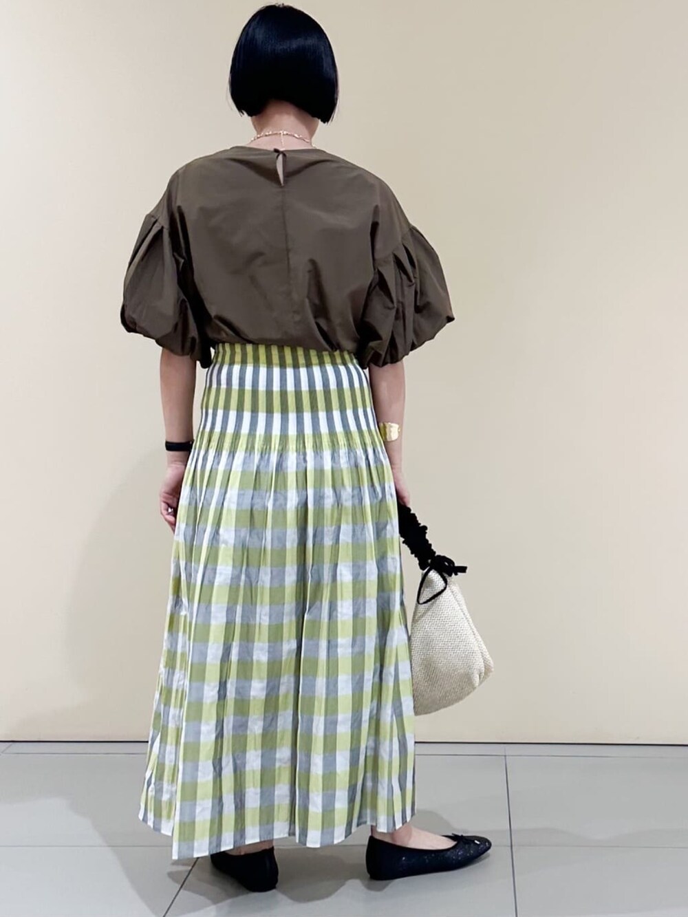 イエロー系のスカート、ブラック系のパンプス、ブラウン系のシャツ/ブラウスを着用したレディースの夏コーディネートの3枚目の写真