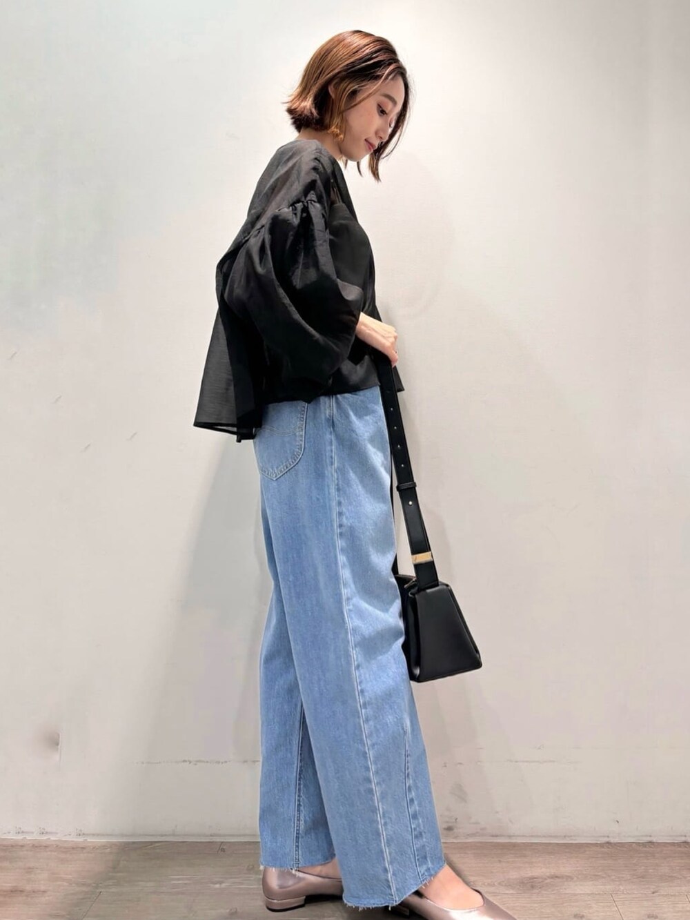 ブラック系のシャツ/ブラウス、シルバー系のパンプス、ブルー系のデニムパンツを着用したレディースの夏コーディネートの3枚目の写真