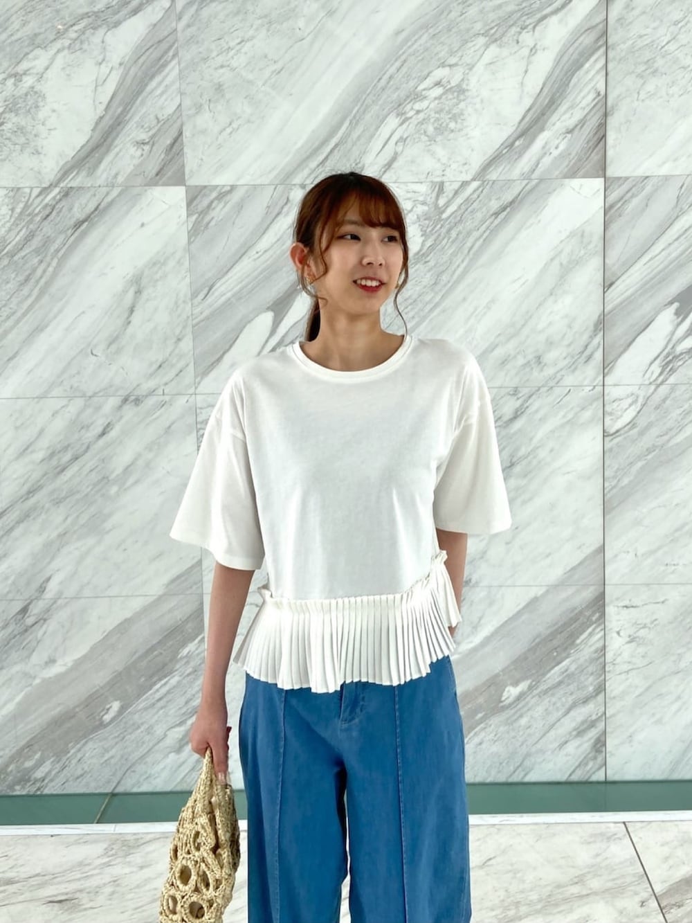 ホワイト系のTシャツ/カットソー、ブルー系のデニムパンツ、ホワイト系のハンドバッグを着用したレディースの夏コーディネートの5枚目の写真