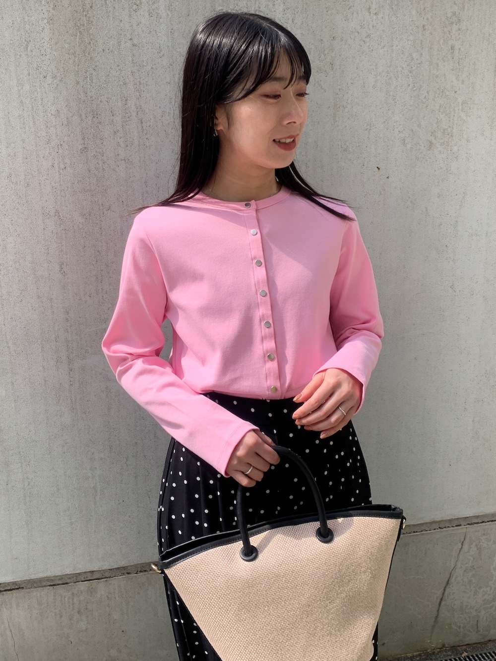 ピンク系のカーディガン/ボレロ、ブラック系のトートバッグ、ブラック系のスカートを着用したレディースの春コーディネートの4枚目の写真