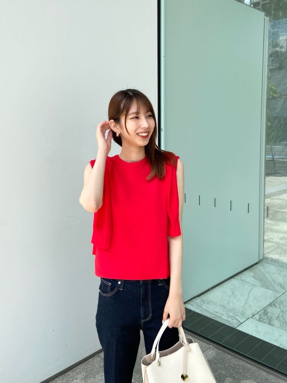 レッド系のカーディガン/ボレロ、レッド系のニット/セーター、ブルー系のデニムパンツを着用したレディースの夏コーディネートの5枚目の写真