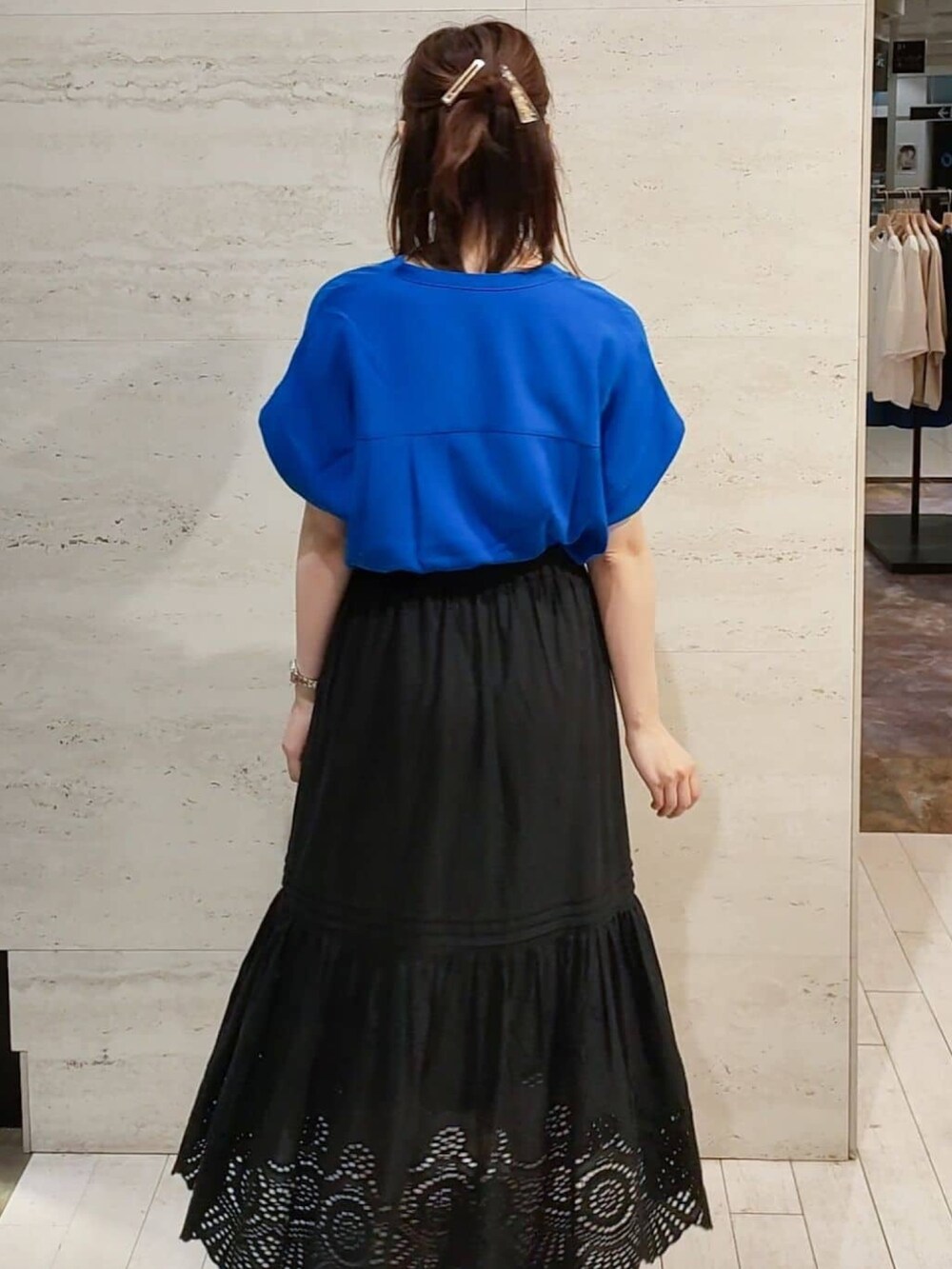 ブルー系のシャツ/ブラウス、ブラック系のスカート、ホワイト系のサンダルを着用したレディースの春コーディネートの6枚目の写真