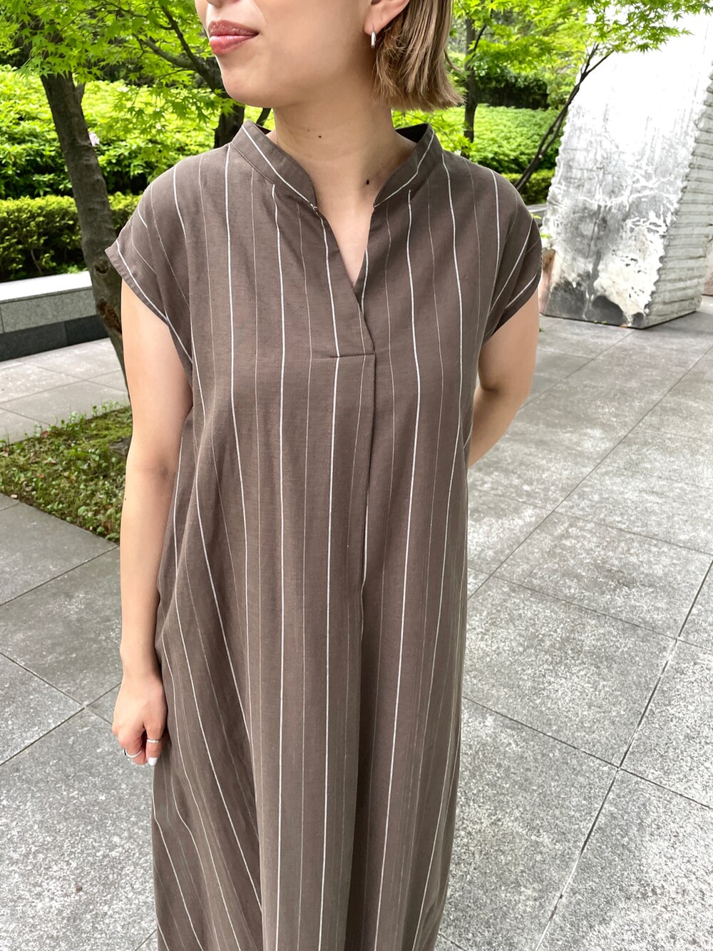 ブラウン系のワンピース、オレンジ系のサンダルを着用したレディースの春コーディネートの4枚目の写真