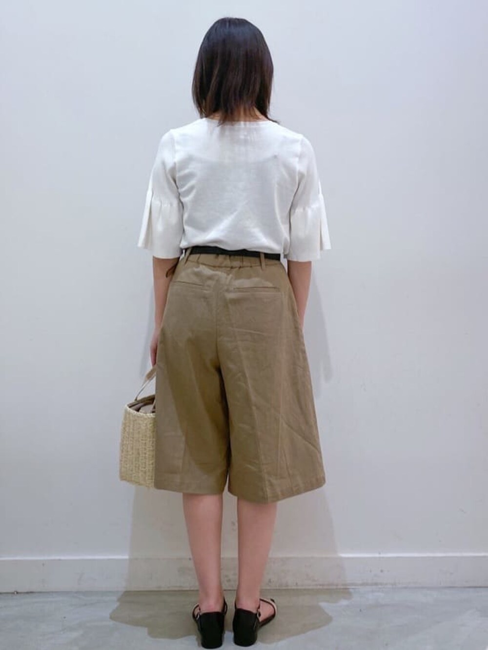 ホワイト系のニット/セーター、ベージュ系のトートバッグ、ブラウン系のその他パンツを着用したレディースの夏コーディネートの3枚目の写真