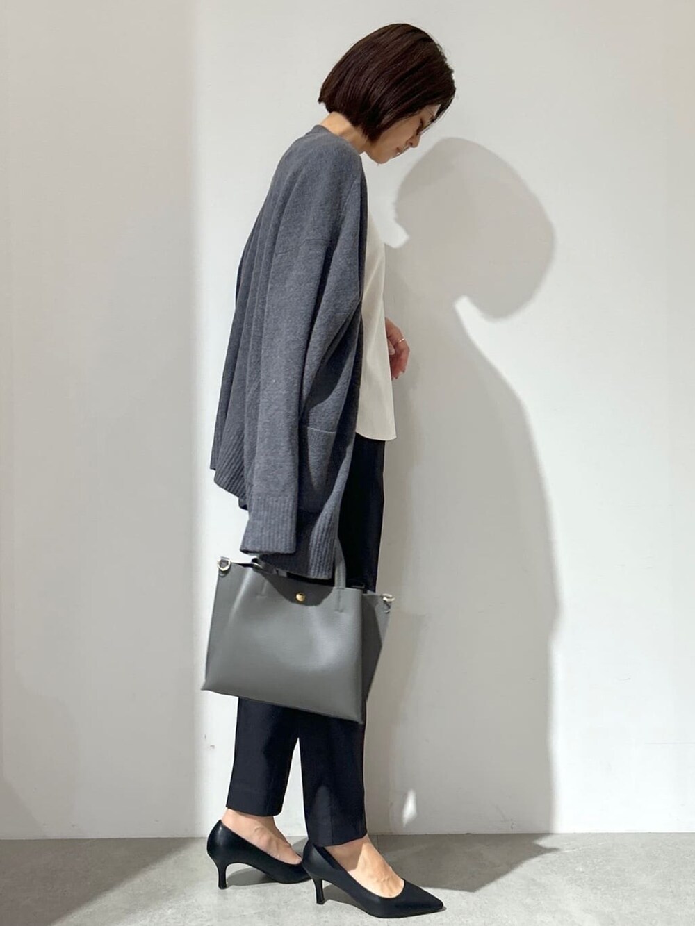 ホワイト系のTシャツ/カットソー、グレー系のカーディガン/ボレロ、ブラック系のその他パンツを着用したレディースの秋コーディネートの4枚目の写真