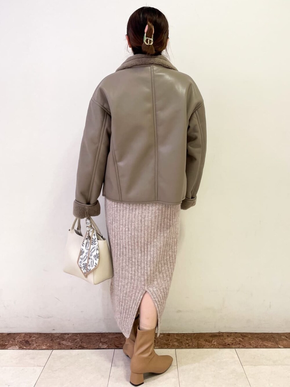 ベージュ系のブーツ、ベージュ系のワンピース、ホワイト系のトートバッグを着用したレディースの冬コーディネートの4枚目の写真