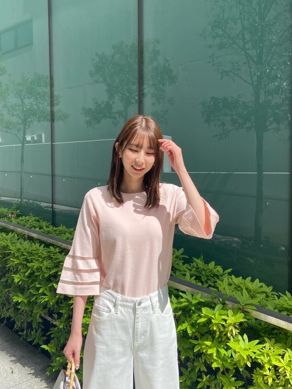 ピンク系のニット/セーター、ホワイト系のデニムパンツ、ホワイト系のサンダルを着用したレディースの春コーディネートの7枚目の写真