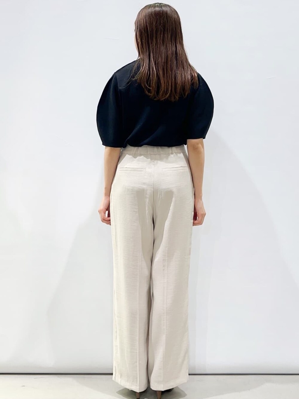 ブラック系のニット/セーター、ベージュ系のその他パンツ、ブラウン系のサンダルを着用したレディースの春コーディネートの3枚目の写真