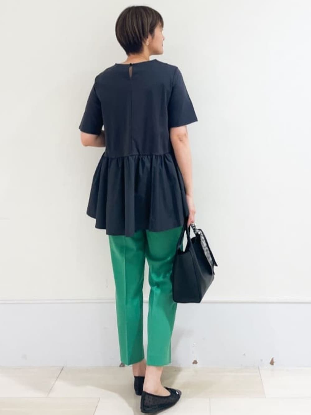 グレー系のTシャツ/カットソー、グリーン系のその他パンツ、ブラック系のトートバッグを着用したレディースの春コーディネートの2枚目の写真