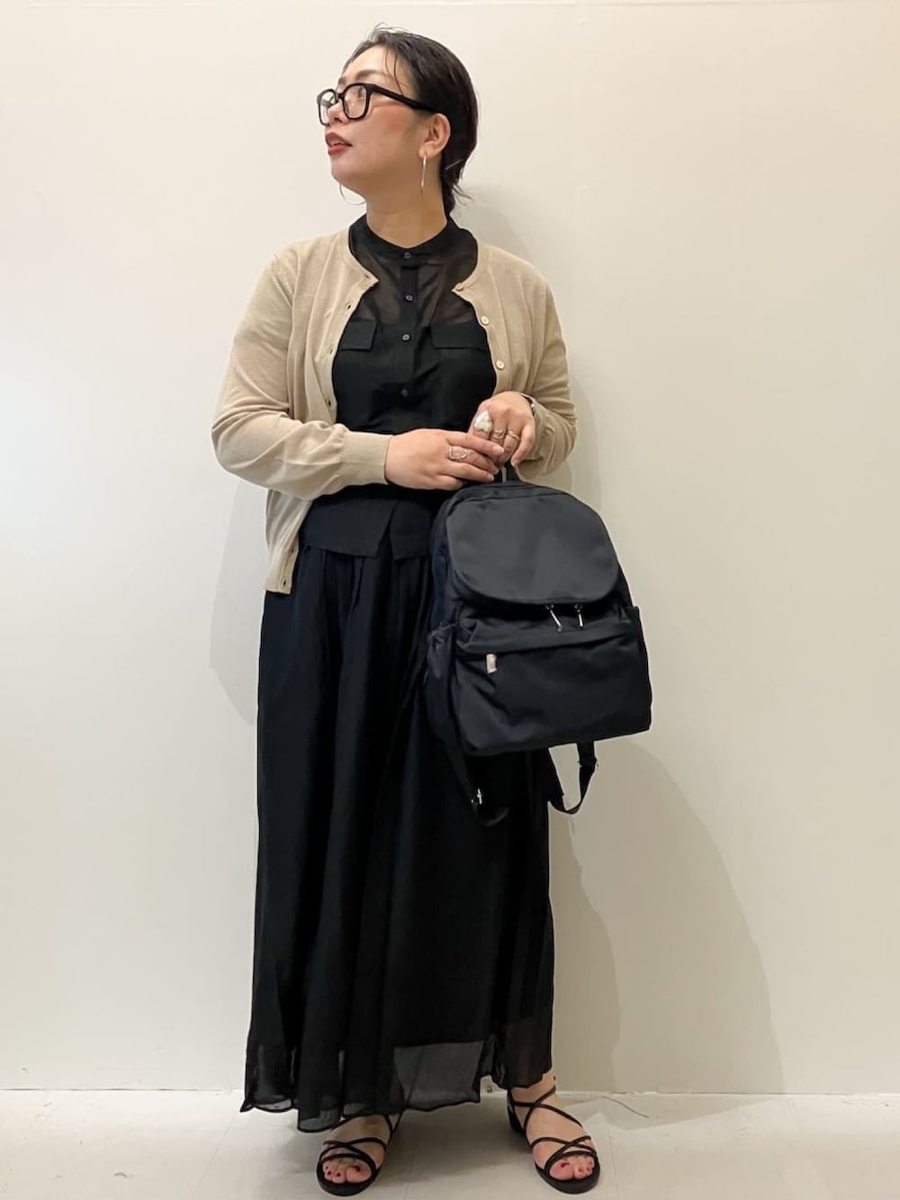 ベージュ系のカーディガン/ボレロ、ブラック系のシャツ/ブラウス、ブラック系のスカートを着用したレディースの春コーディネートの3枚目の写真