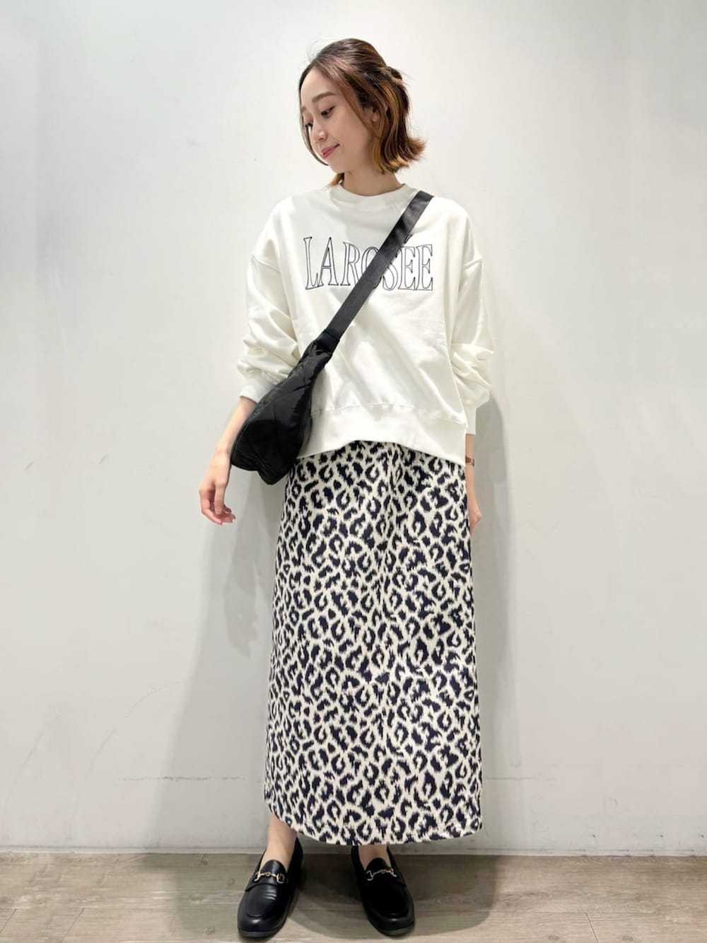 ブルー系のスカート、ブラウン系のベスト、ホワイト系のTシャツ/カットソーを着用したレディースの秋コーディネートの4枚目の写真