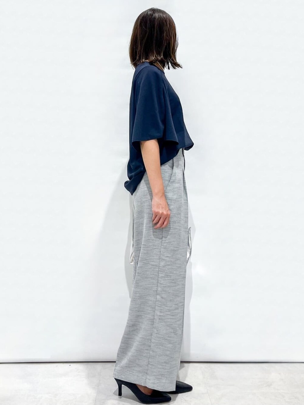 ブラック系のその他パンツ、ブラック系のパンプス、シルバー系のトートバッグを着用したレディースの夏コーディネートの5枚目の写真