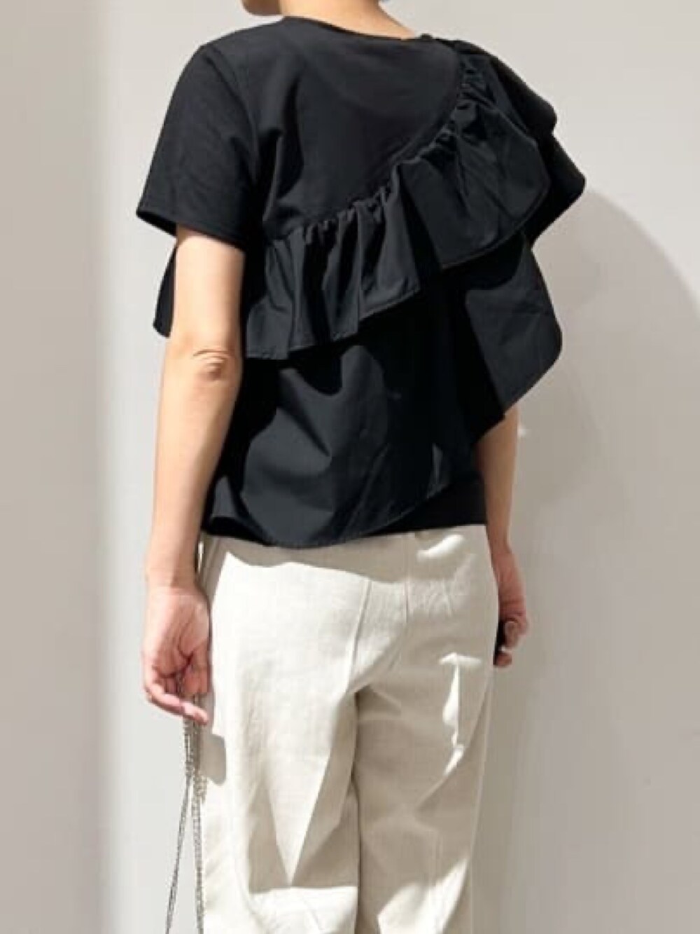 ブラック系のTシャツ/カットソー、ホワイト系のその他パンツ、ブラック系のサンダルを着用したレディースの夏コーディネートの3枚目の写真