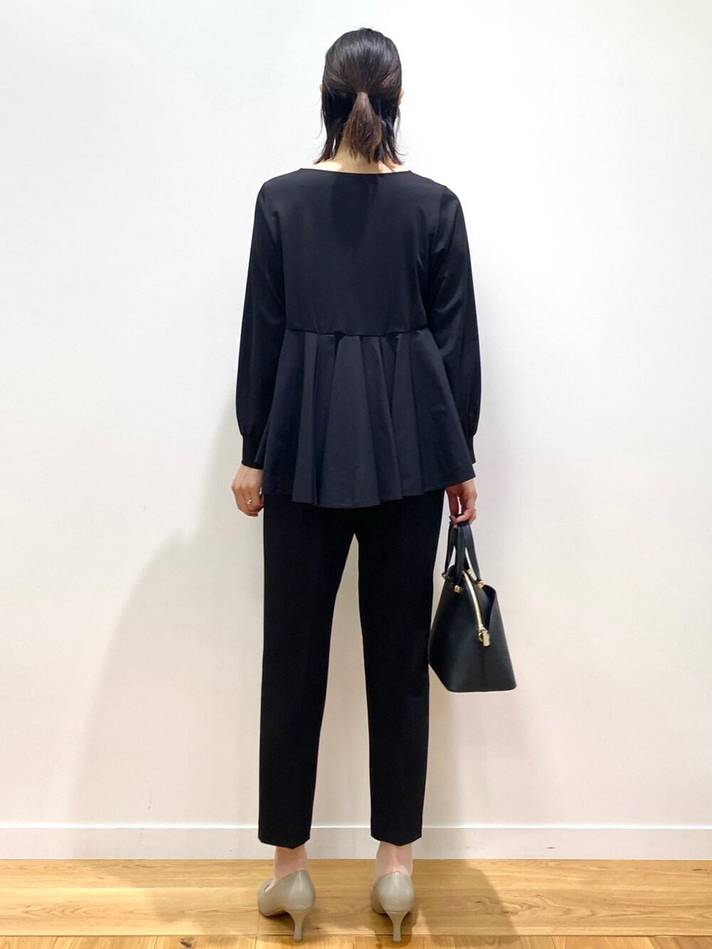 ブラック系のTシャツ/カットソー、ブラック系のその他パンツ、グリーン系のパンプスを着用したレディースの冬コーディネートの2枚目の写真