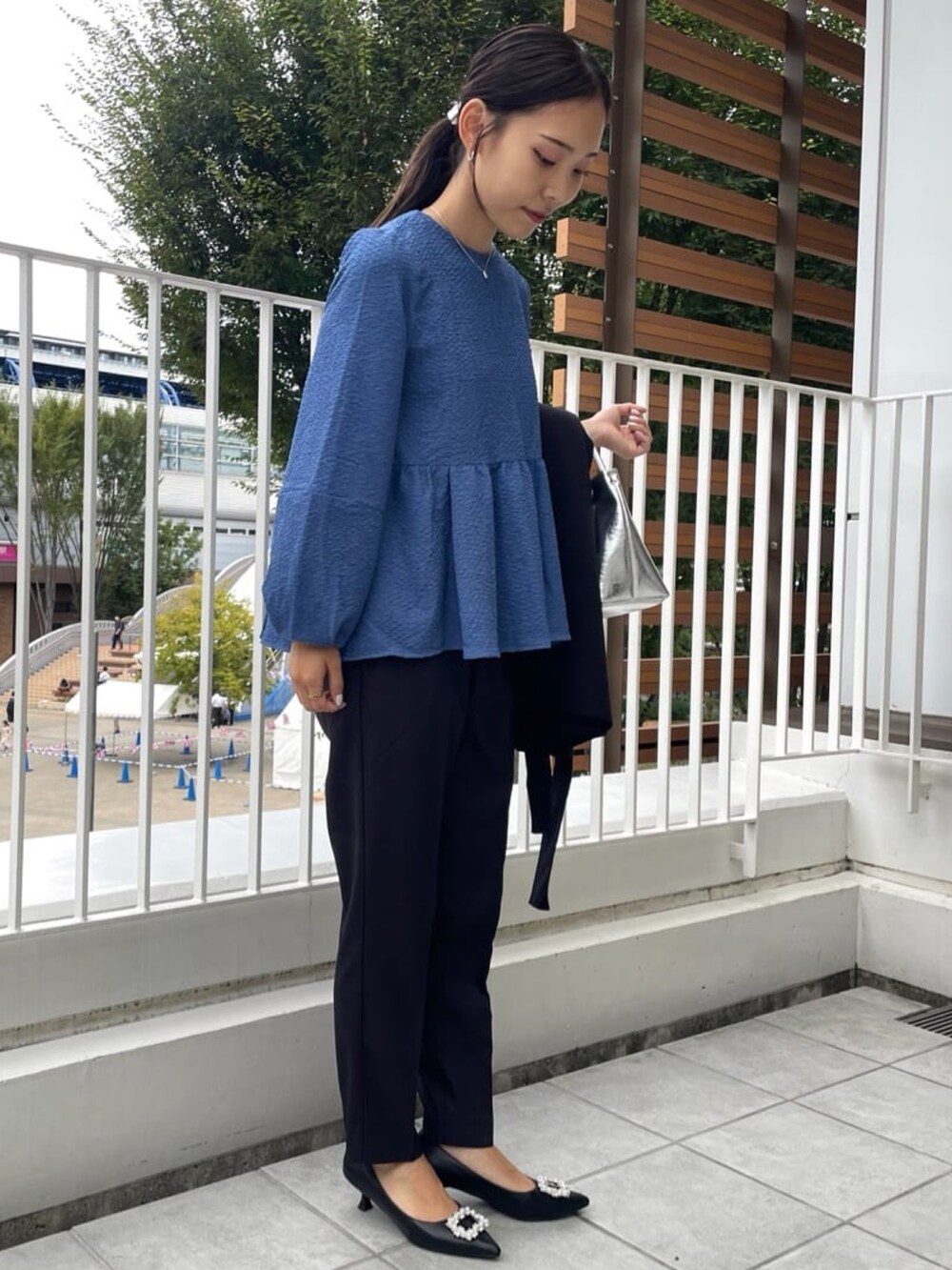 シルバー系のトートバッグ、ブラック系のその他パンツ、ブラック系のパンプスを着用したレディースの秋コーディネートの5枚目の写真