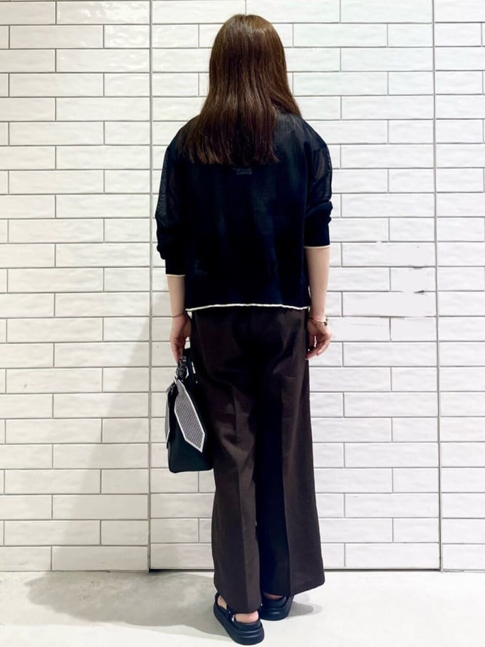 ブラック系のカーディガン/ボレロ、ベージュ系のニット/セーター、ブラック系のトートバッグを着用したレディースの夏コーディネートの3枚目の写真