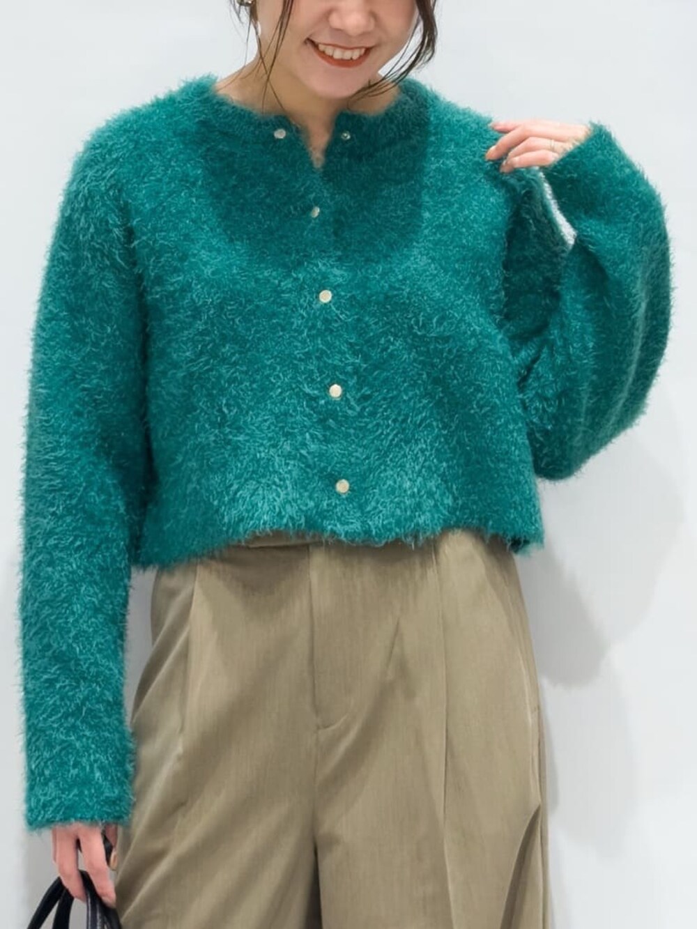 グリーン系のカーディガン/ボレロ、ブラウン系のその他パンツ、ブラック系のトートバッグを着用したレディースの秋コーディネートの4枚目の写真