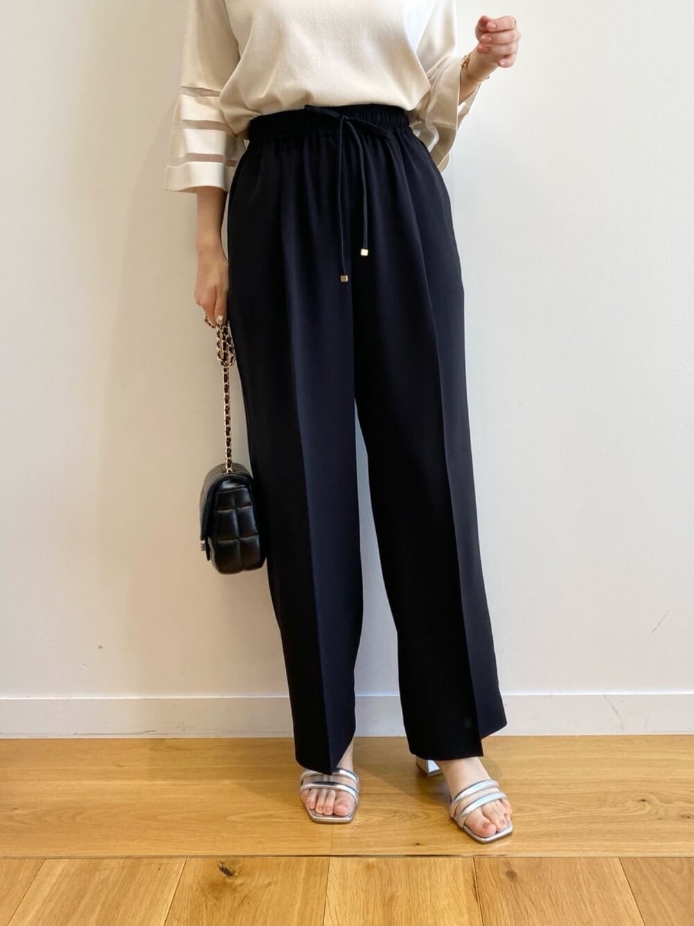 ホワイト系のニット/セーター、ブラック系のその他パンツ、ブラック系のショルダーバッグを着用したレディースの春コーディネートの8枚目の写真