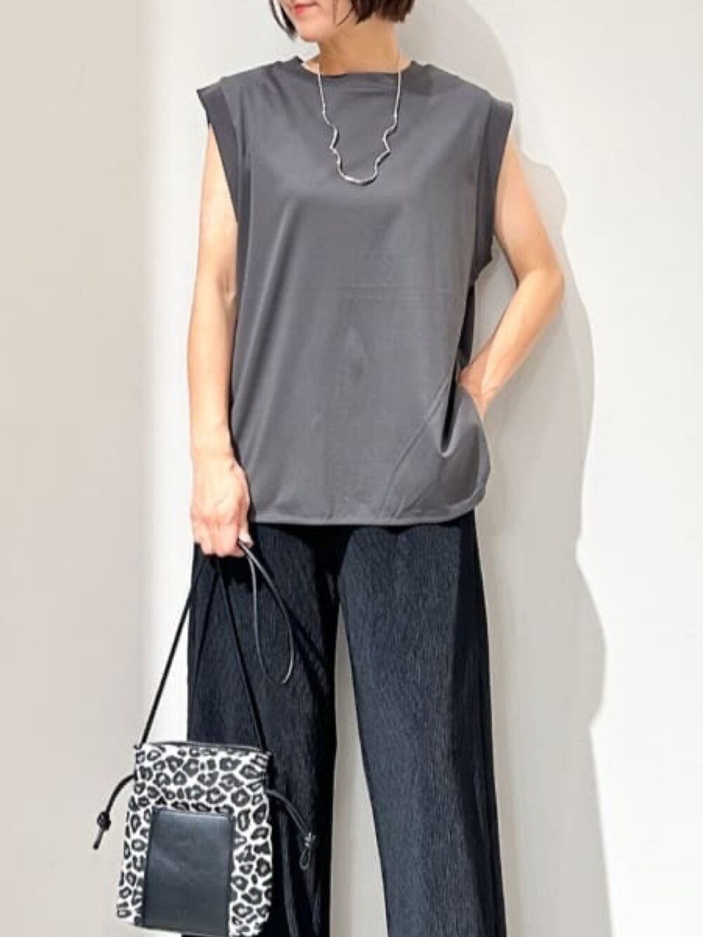 ブラック系のその他パンツ、ホワイト系のショルダーバッグ、ブラック系のサンダルを着用したレディースの夏コーディネートの5枚目の写真