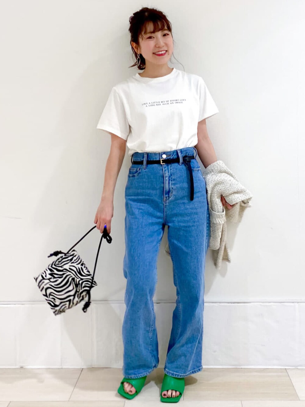 ホワイト系のカーディガン/ボレロ、ホワイト系のTシャツ/カットソー、ブルー系のデニムパンツを着用したレディースの春コーディネートの3枚目の写真