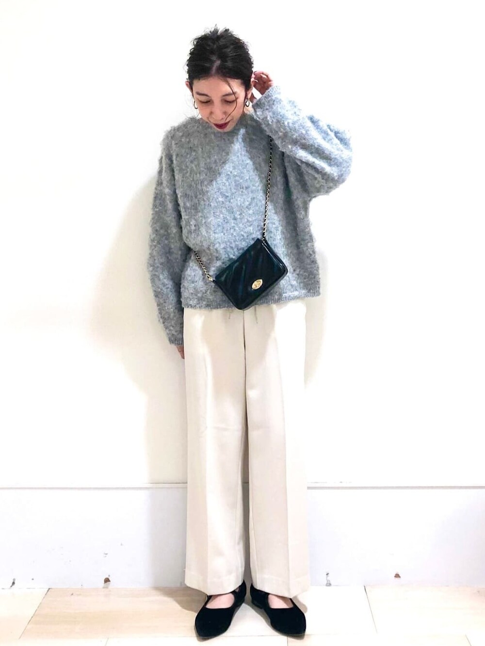 ベージュ系のチェスターコート、ホワイト系のその他パンツ、グレー系のニット/セーターを着用したレディースの冬コーディネートの3枚目の写真