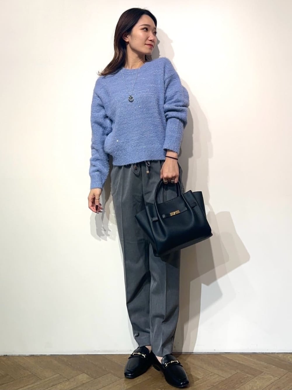 グレー系のその他パンツ、ブラック系のドレスシューズ、ブラック系のノーカラーコートを着用したレディースの冬コーディネートの4枚目の写真