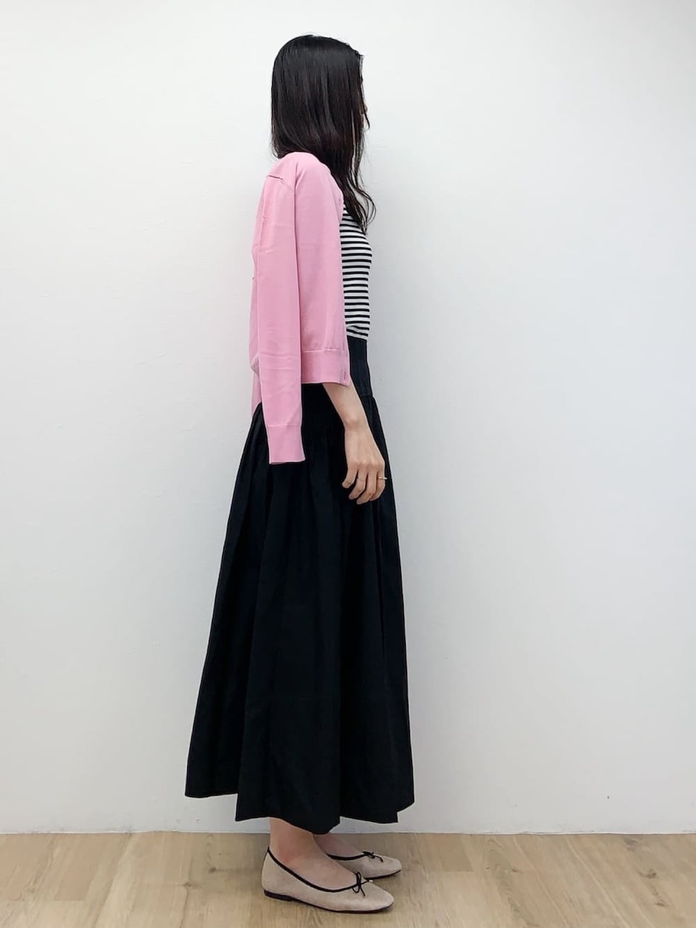 ピンク系のカーディガン/ボレロ、ブラック系のスカート、ベージュ系のその他シューズを着用したレディースの春コーディネートの2枚目の写真