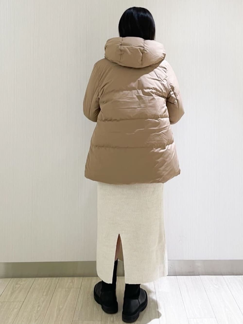 ホワイト系のスカート、ホワイト系のニット/セーター、イエロー系のダウンジャケット/コートを着用したレディースの秋コーディネートの3枚目の写真