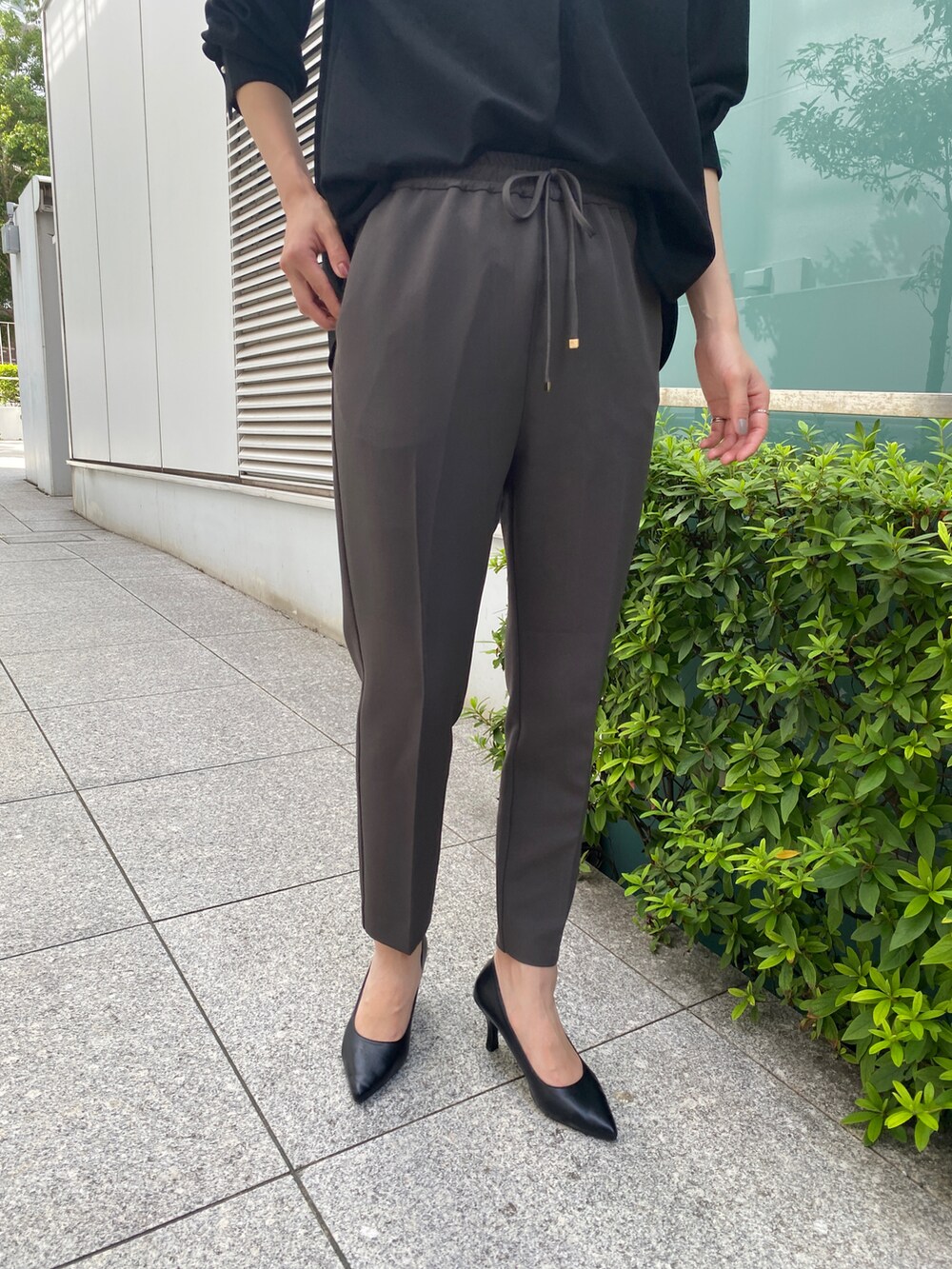 ブラック系のTシャツ/カットソー、グレー系のその他パンツ、ブラック系のパンプスを着用したレディースの秋コーディネートの5枚目の写真
