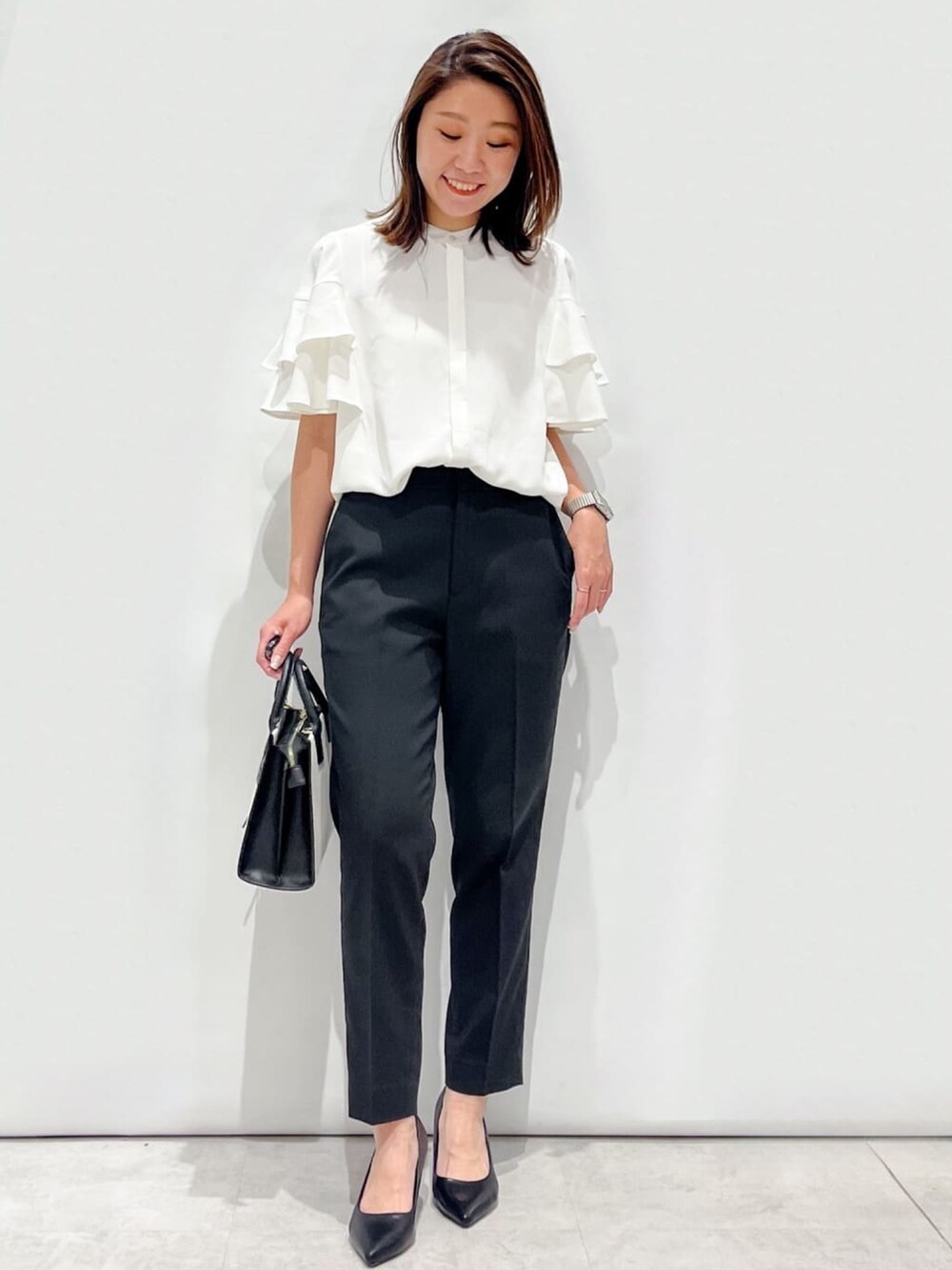 グレー系のノーカラージャケット、ホワイト系のシャツ/ブラウス、ブラック系のパンプスを着用したレディースの夏コーディネートの6枚目の写真