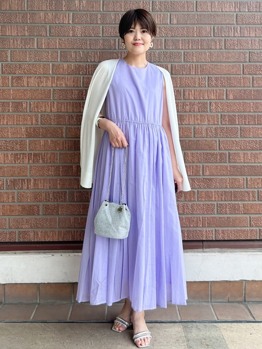 ホワイト系のカーディガン/ボレロ、パープル系のワンピース、ホワイト系のショルダーバッグを着用したレディースの夏コーディネートの2枚目の写真