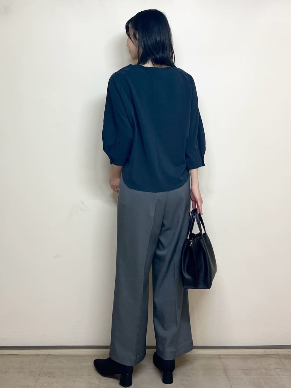 ブルー系のTシャツ/カットソー、グレー系のその他パンツ、ブラック系のトートバッグを着用したレディースの秋コーディネートの4枚目の写真