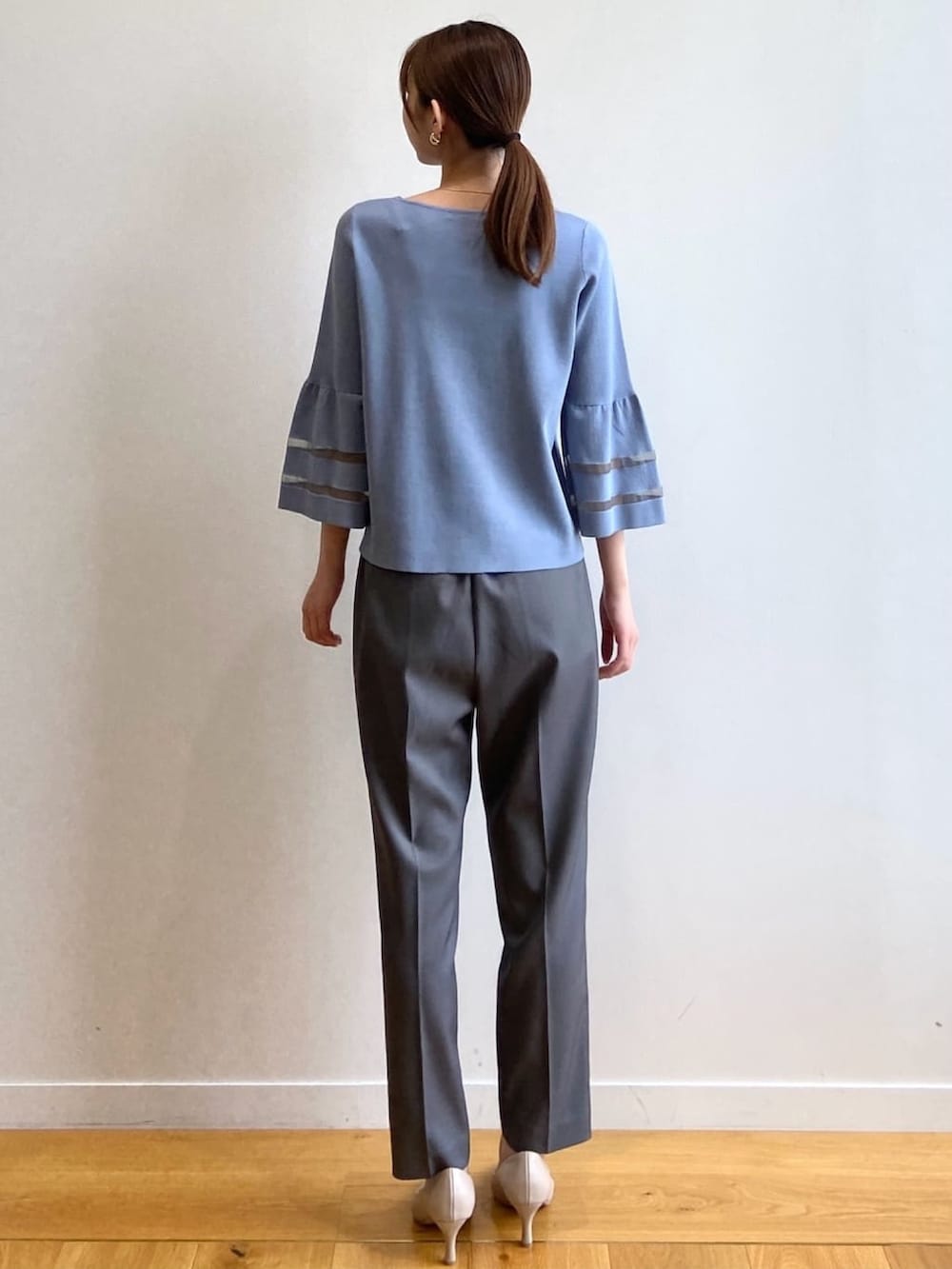 グレー系のその他パンツ、ベージュ系のパンプス、ブルー系のニット/セーターを着用したレディースの秋コーディネートの4枚目の写真