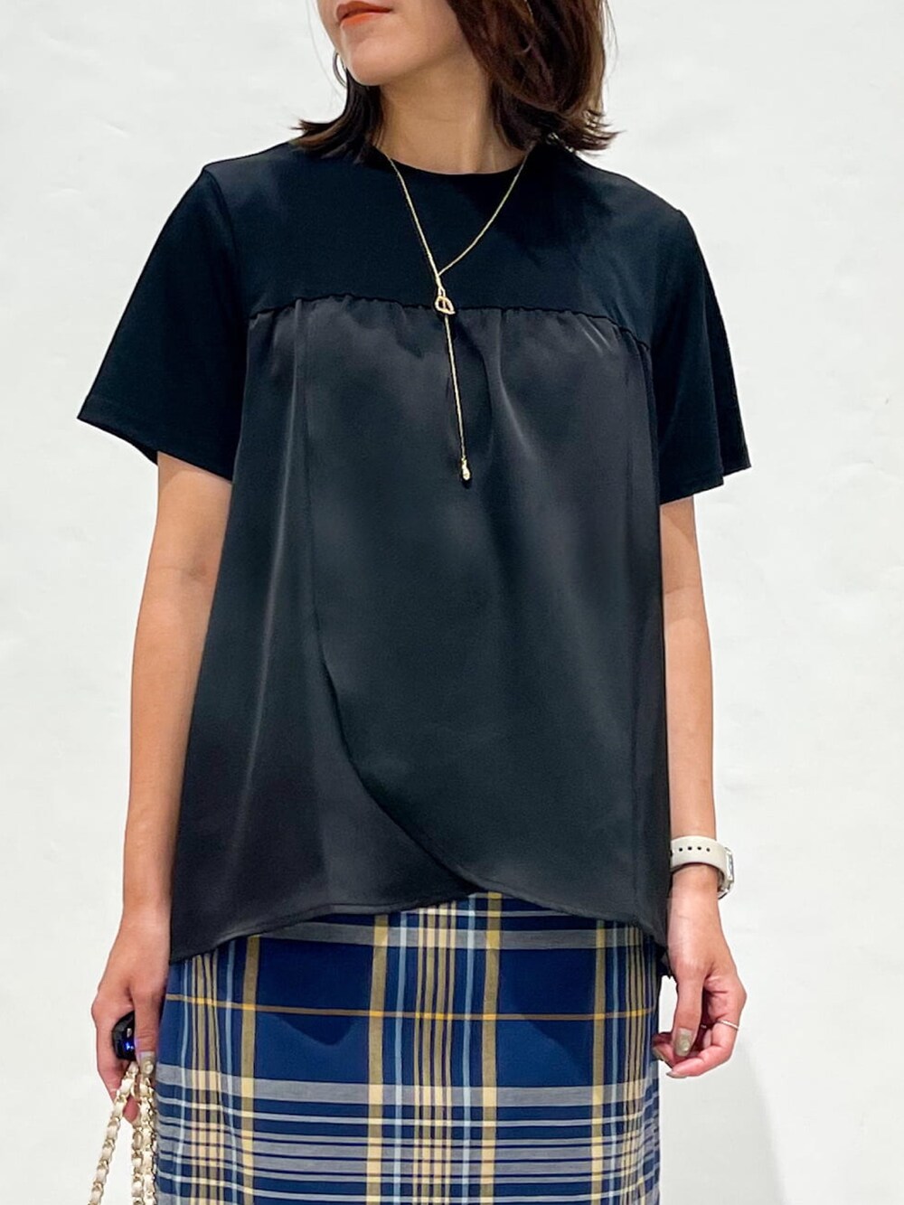 ブルー系のスカート、ブラック系のパンプス、ホワイト系のショルダーバッグを着用したレディースの夏コーディネートの7枚目の写真