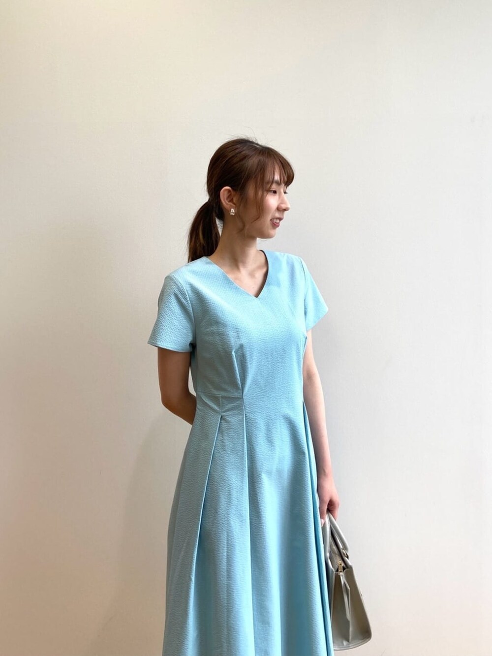 ブルー系のワンピース、シルバー系のサンダル、グレー系のハンドバッグを着用したレディースの夏コーディネートの6枚目の写真