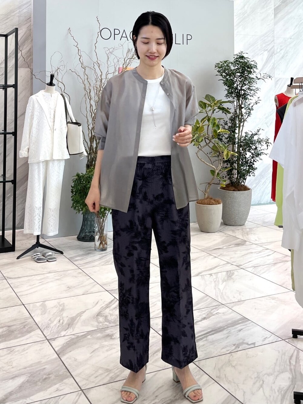 グレー系のその他パンツ、グリーン系のサンダル、グレー系のシャツ/ブラウスを着用したレディースの春コーディネートの2枚目の写真