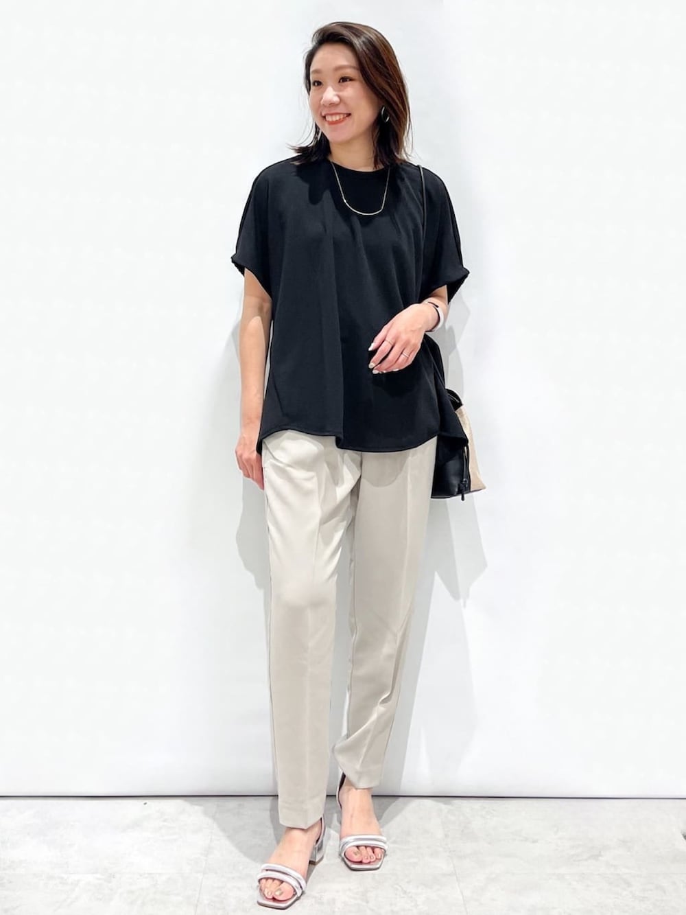 ブラック系のTシャツ/カットソー、グレー系のその他パンツ、シルバー系のサンダルを着用したレディースの春コーディネートの3枚目の写真