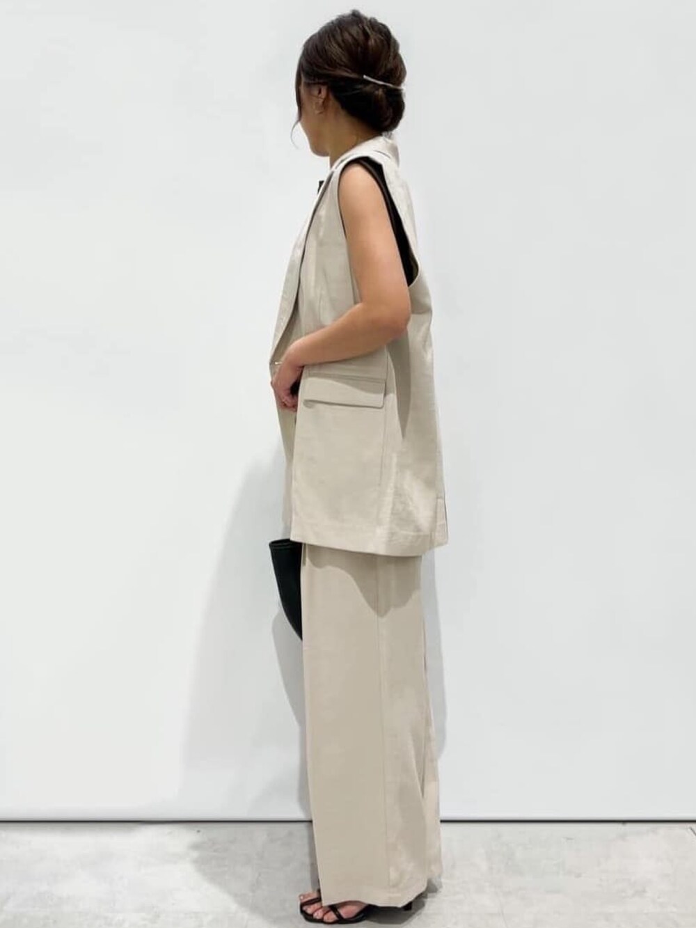 ベージュ系のその他パンツ、ブラック系のトートバッグ、ブラック系のサンダルを着用したレディースの夏コーディネートの2枚目の写真