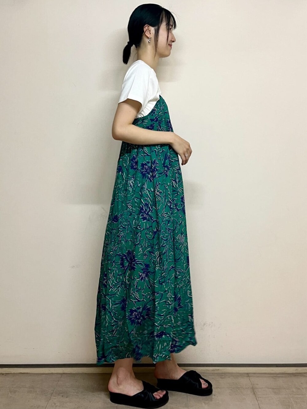 グリーン系のワンピース、ホワイト系のTシャツ/カットソー、ブラック系のサンダルを着用したレディースの夏コーディネートの2枚目の写真