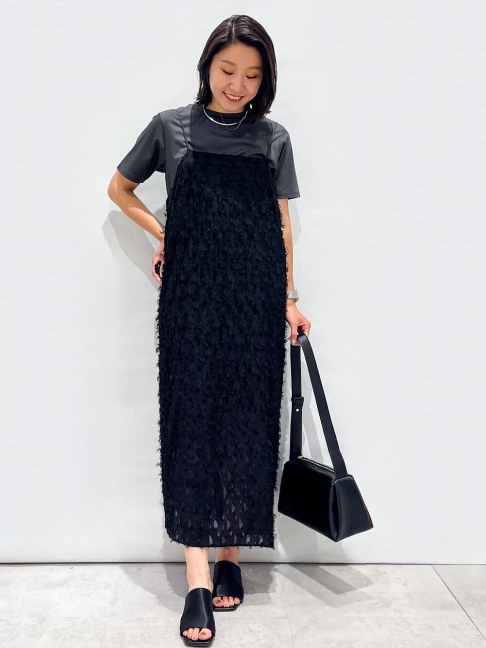 ブラック系のサンダル、ブラック系のショルダーバッグ、ブラック系のワンピースを着用したレディースの夏コーディネートの6枚目の写真