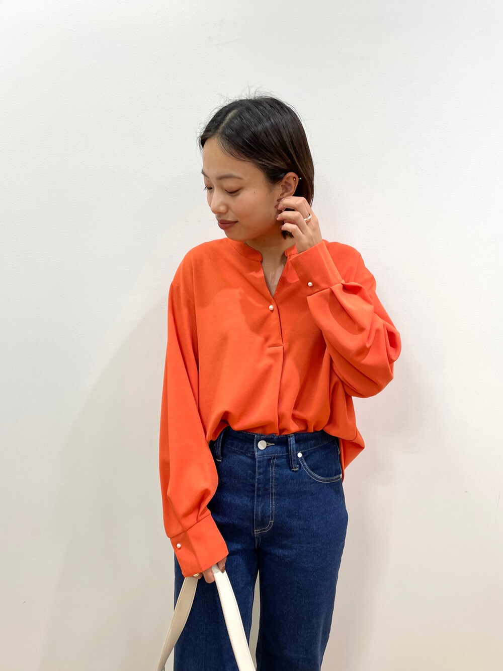 オレンジ系のTシャツ/カットソー、ブルー系のその他パンツ、ブラック系のブーツを着用したレディースの秋コーディネートの4枚目の写真