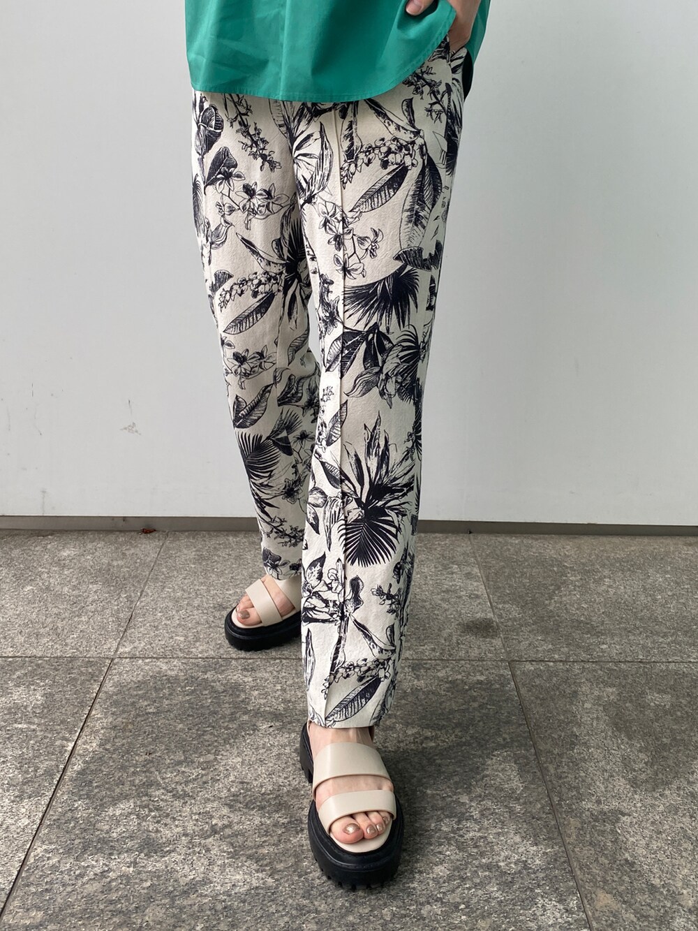 グリーン系のシャツ/ブラウス、ベージュ系のその他パンツ、ホワイト系のサンダルを着用したレディースの春コーディネートの3枚目の写真