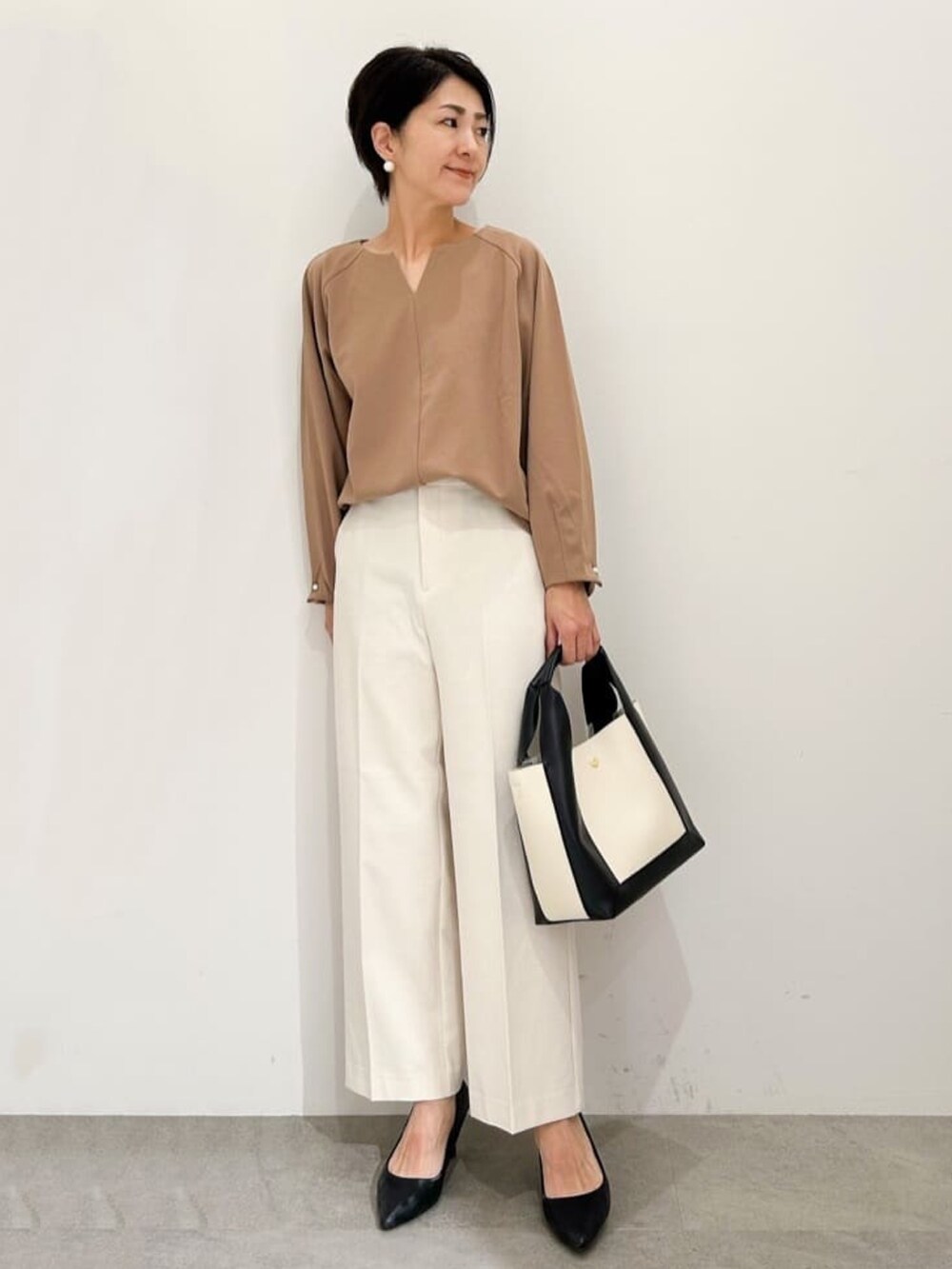 ブラック系のパンプス、ホワイト系のその他パンツ、ブラウン系のTシャツ/カットソーを着用したレディースの秋コーディネートの3枚目の写真