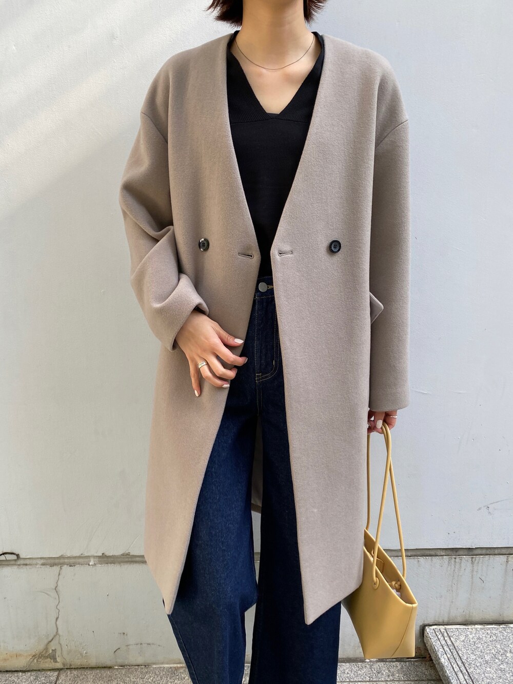 グレー系のノーカラーコート、ブルー系のその他パンツ、ブルー系のニット/セーターを着用したレディースの秋コーディネートの3枚目の写真