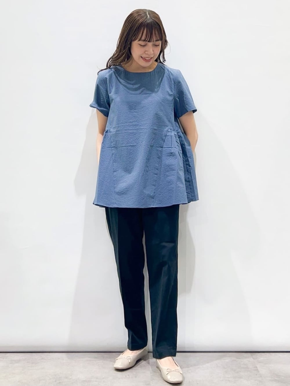 ブルー系のシャツ/ブラウス、ブラック系のその他パンツ、グレー系のパンプスを着用したレディースの夏コーディネートの2枚目の写真