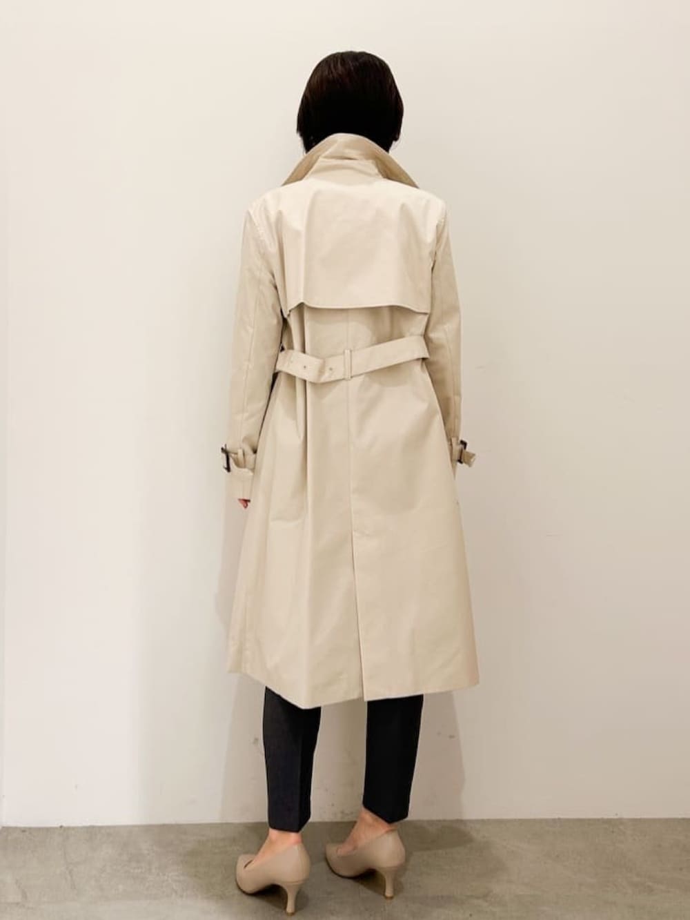 ベージュ系のトレンチコート、ブルー系のニット/セーター、グレー系のその他パンツを着用したレディースの冬コーディネートの2枚目の写真