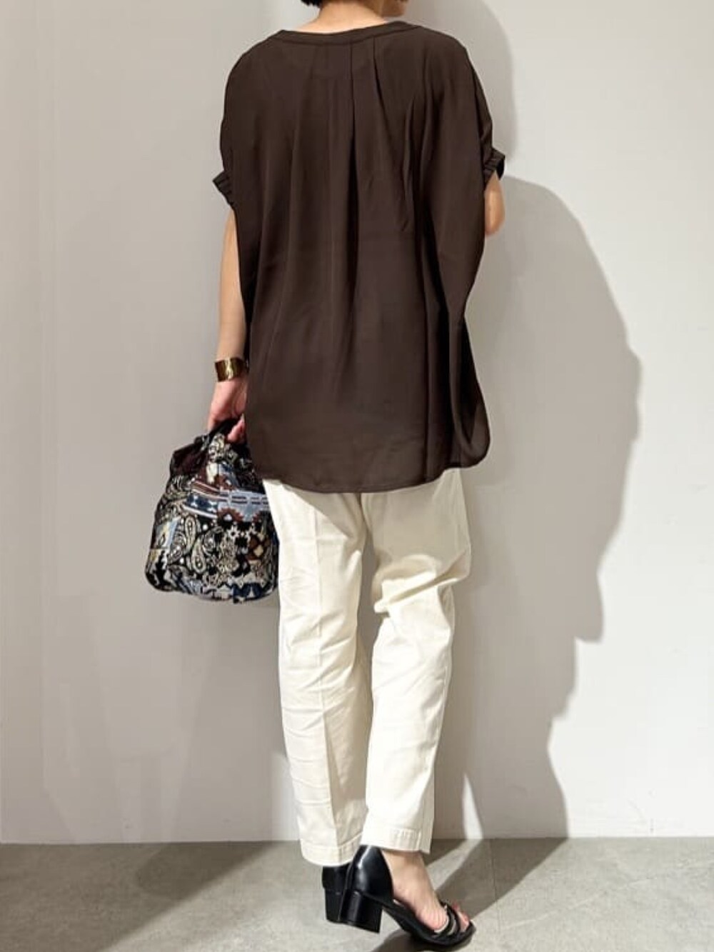 ブラウン系のTシャツ/カットソー、ブルー系のハンドバッグ、ブラック系のサンダルを着用したレディースの夏コーディネートの5枚目の写真