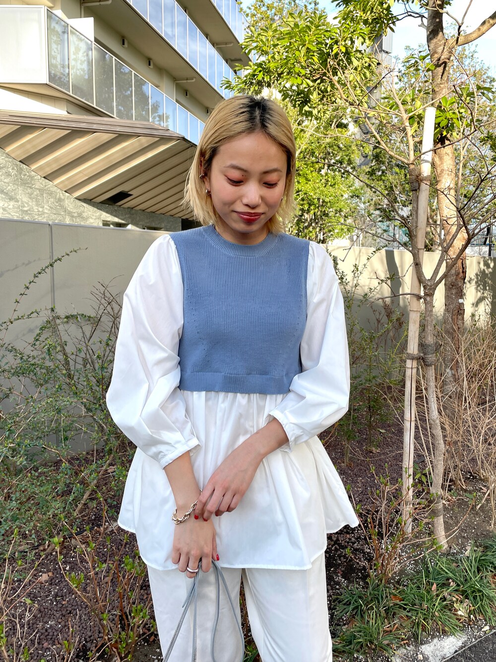 ブルー系のニット/セーター、ホワイト系のその他パンツ、ホワイト系のスニーカーを着用したレディースの春コーディネートの3枚目の写真