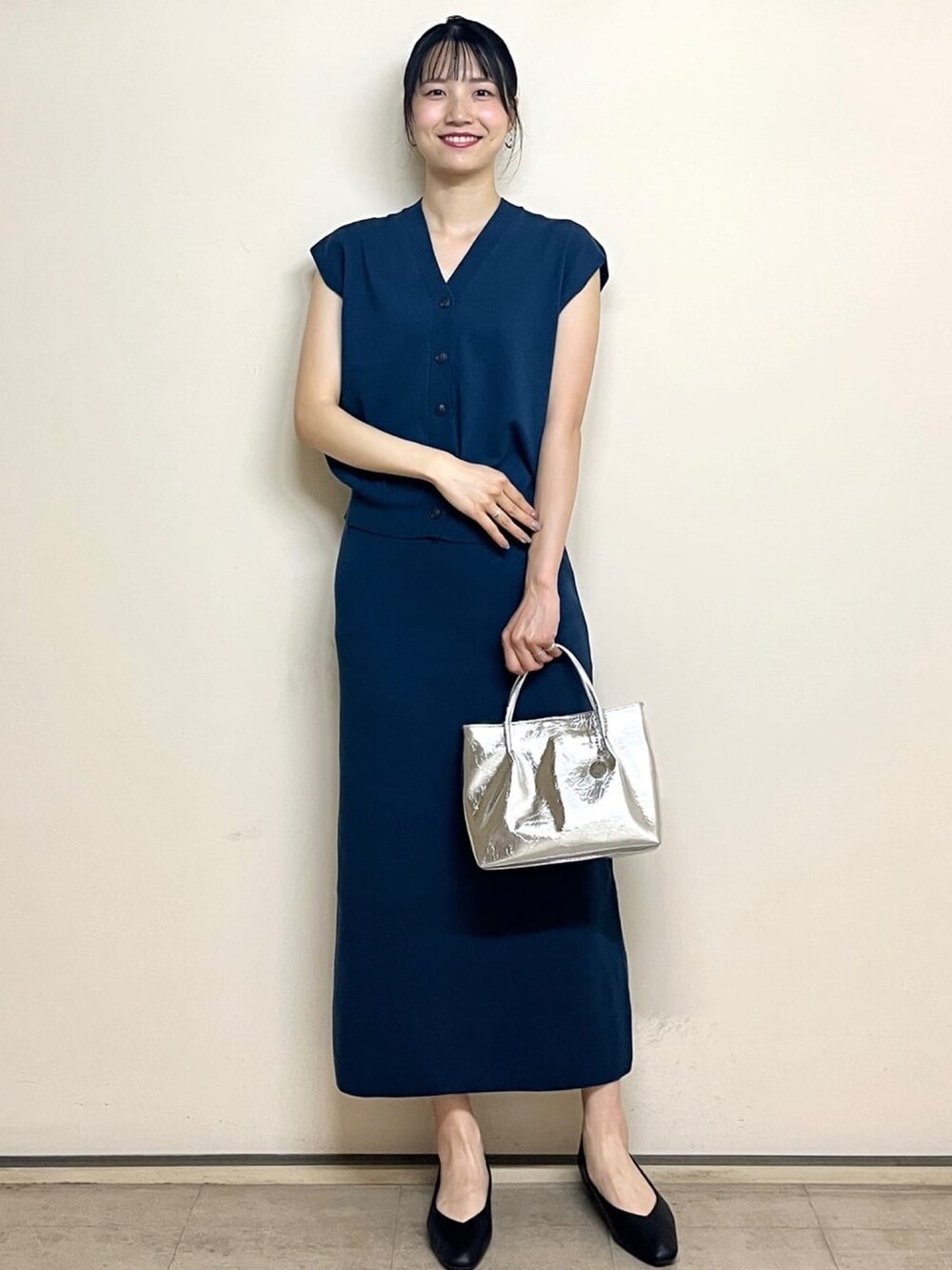 ブルー系のベスト、ブルー系のスカート、シルバー系のトートバッグを着用したレディースの夏コーディネートの7枚目の写真